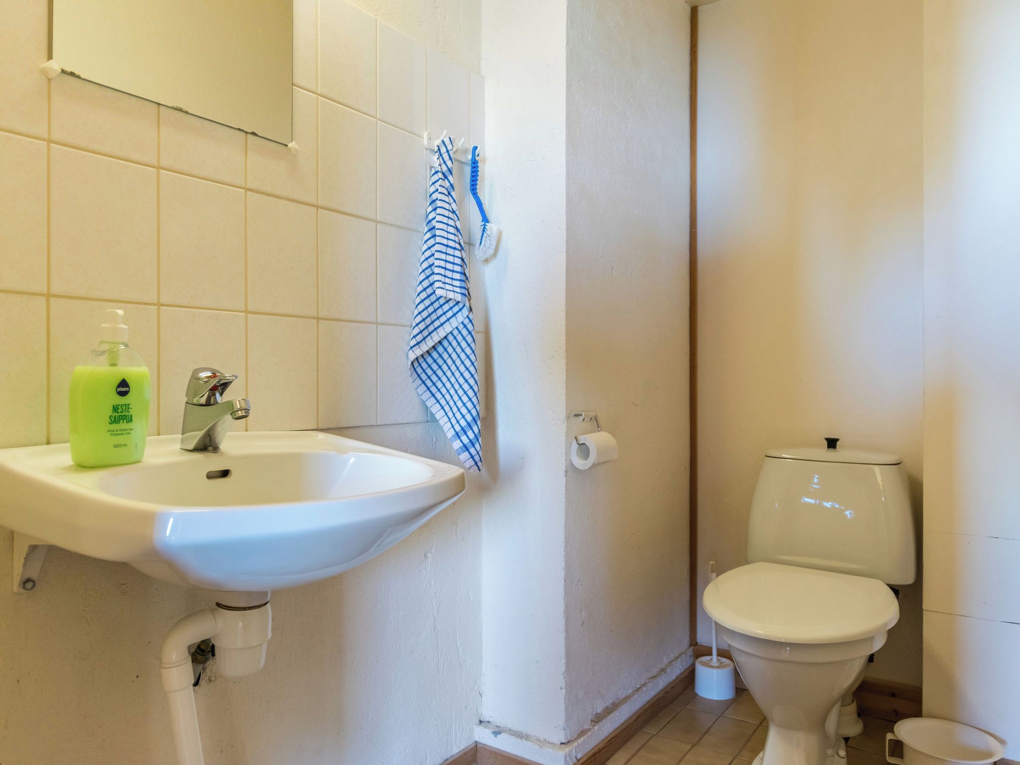 Een badkamer met een wit wastafelmeubel, toilet en douchecabine.