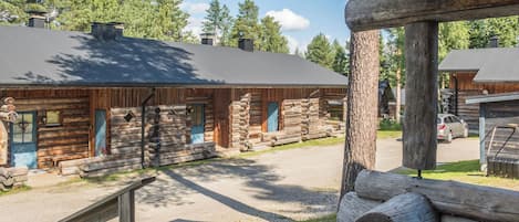 A log cabin with a gravel driveway and a wooden deck.