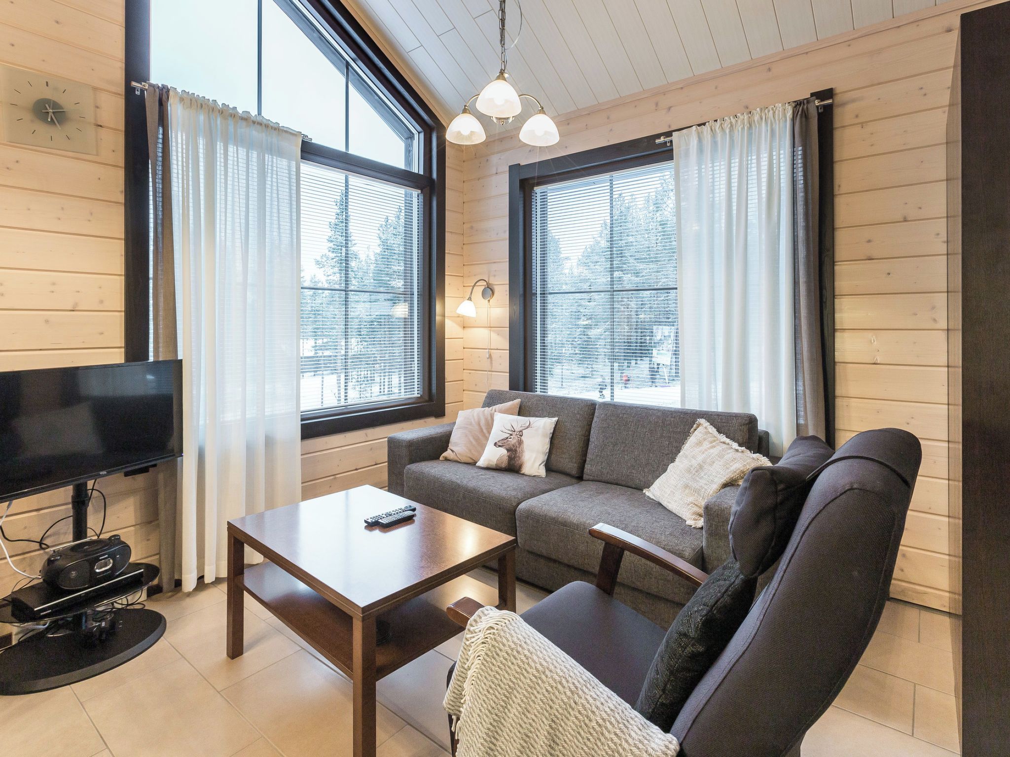 A cozy living room with a sofa, a coffee table, and a TV.