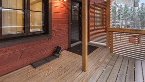 Eine Holzhütte mit Balkon, einer Tür und einem Fenster mit Rollläden.