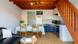 A compact living space with a dining area, kitchenette, and a staircase. - Vacation home Sicard by Interhome (Mimizan)