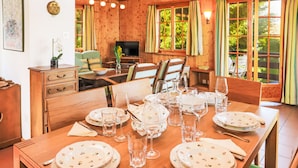 Comedor de madera con una mesa dispuesta para cuatro personas, rodeada de sillas.