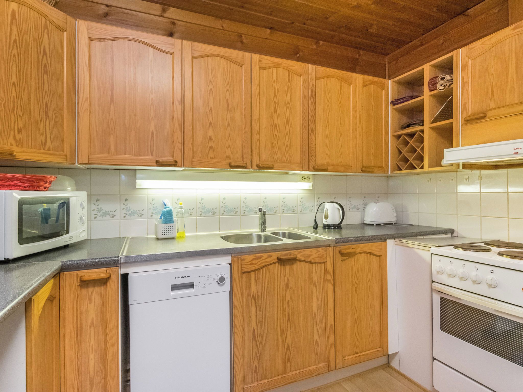 A kitchen with wooden cabinets, a microwave, a dishwasher, a sink, and a stove.