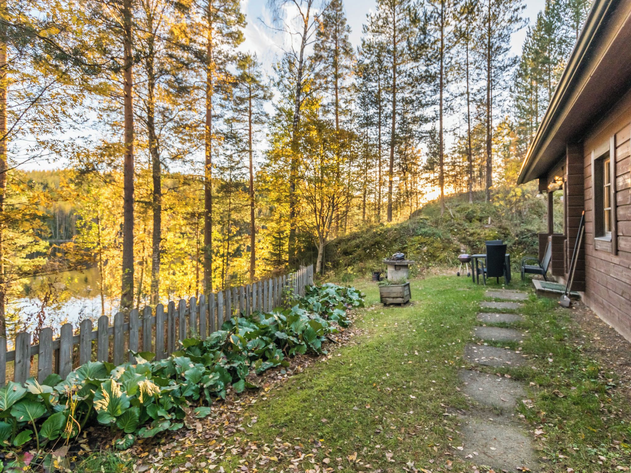 A cabin with a wooden deck and a view of a forested area.