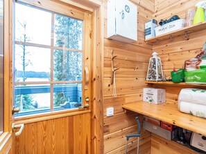 A wooden cabin interior with a large window, a sauna, and storage shelves. - Rukaniemen kontio by Interhome (Kuusamo)