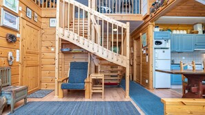 A wooden cabin with a central staircase, a dining area, and a kitchen. - Rukaniemen kontio by Interhome (Kuusamo)