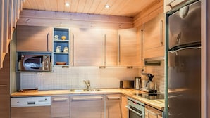 Una cucina moderna con mobili in legno, un frigorifero in acciaio inossidabile, un forno a microonde e una macchina da caffè.