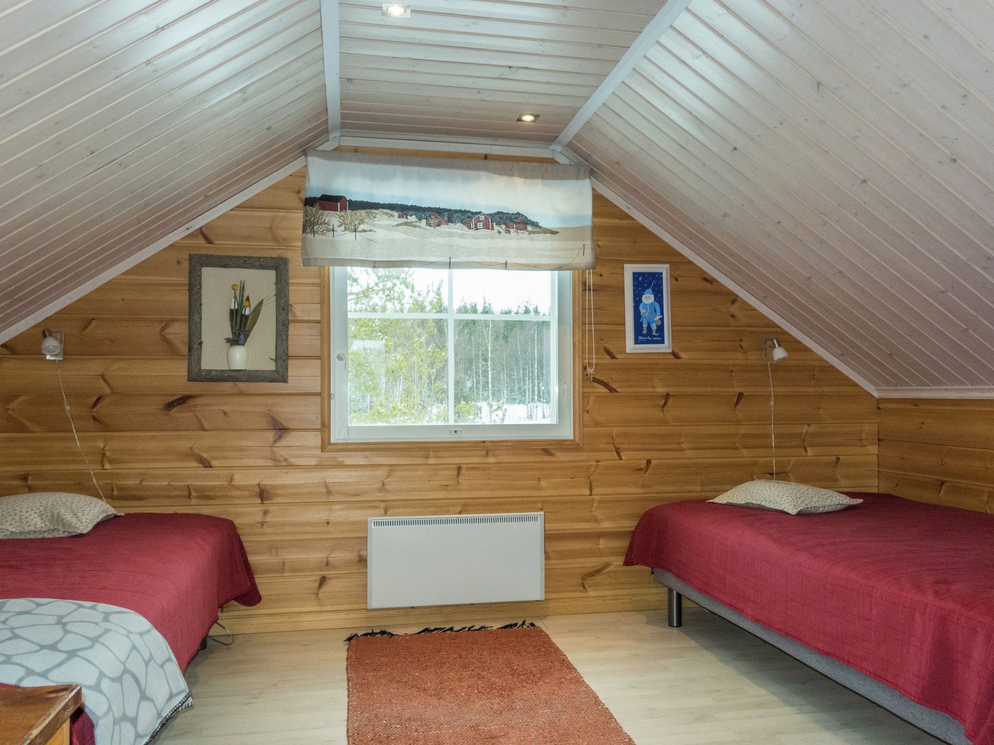 A room with two beds, a window, and a radiator.