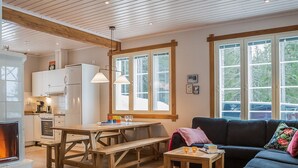 Ein gemütliches Wohnzimmer mit Kamin, einem Holzesstisch und einer Couch.