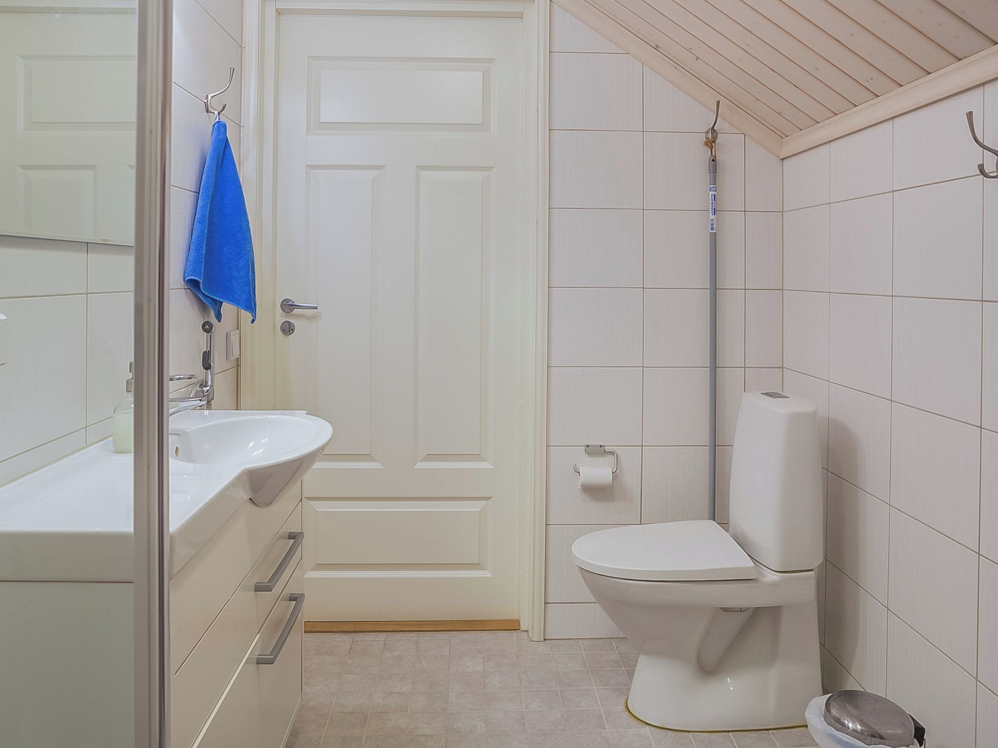 A bathroom with a white sink, toilet, and shower area.