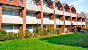 Un immeuble à plusieurs étages, doté d’une façade en briques, de grandes fenêtres et d’un toit plat.