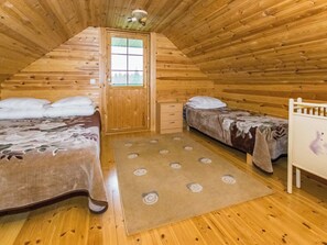 A wooden cabin bedroom with two beds, a small desk, and a window. - Metsämökki by Interhome (Raasepori)