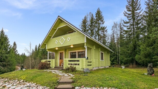 A green lodge with a stone pathway leading to the entrance, surrounded by a forest. - Metsämökki by Interhome (Raasepori)