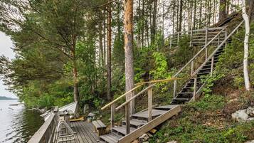 A wooden dock leading to a staircase surrounded by trees.