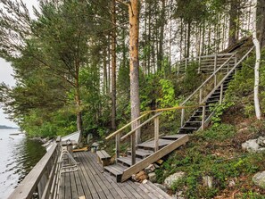 Une jetée en bois menant à un escalier entouré d’arbres.