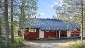 A small, single-story building with a blue-tiled roof, surrounded by trees. - Rintelä 5a by Interhome (Kuusamo)
