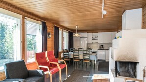 A cozy cabin interior with a dining area, kitchen, and seating space. - Rintelä 5a by Interhome (Kuusamo)