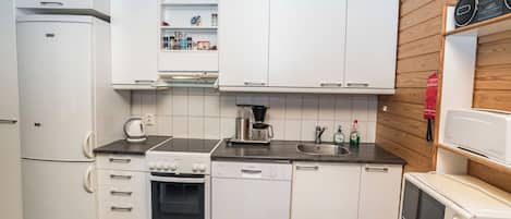 A compact kitchen with white cabinetry, a stove, oven, dishwasher, and a microwave.