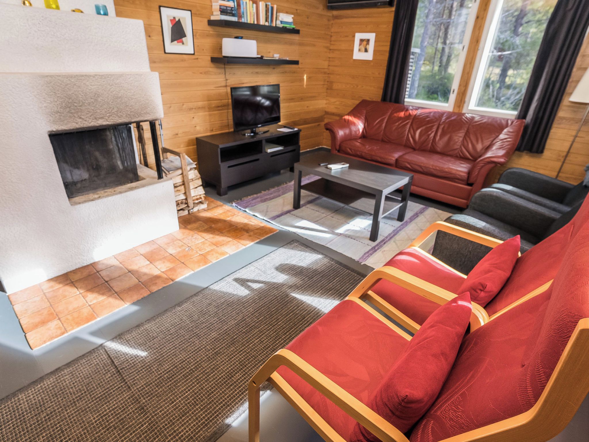 A living room with a fireplace, leather sofa, and a television.