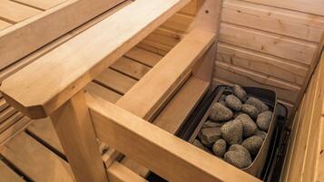 Uma sauna com bancos de madeira e um elemento de aquecimento preenchido com pedras.