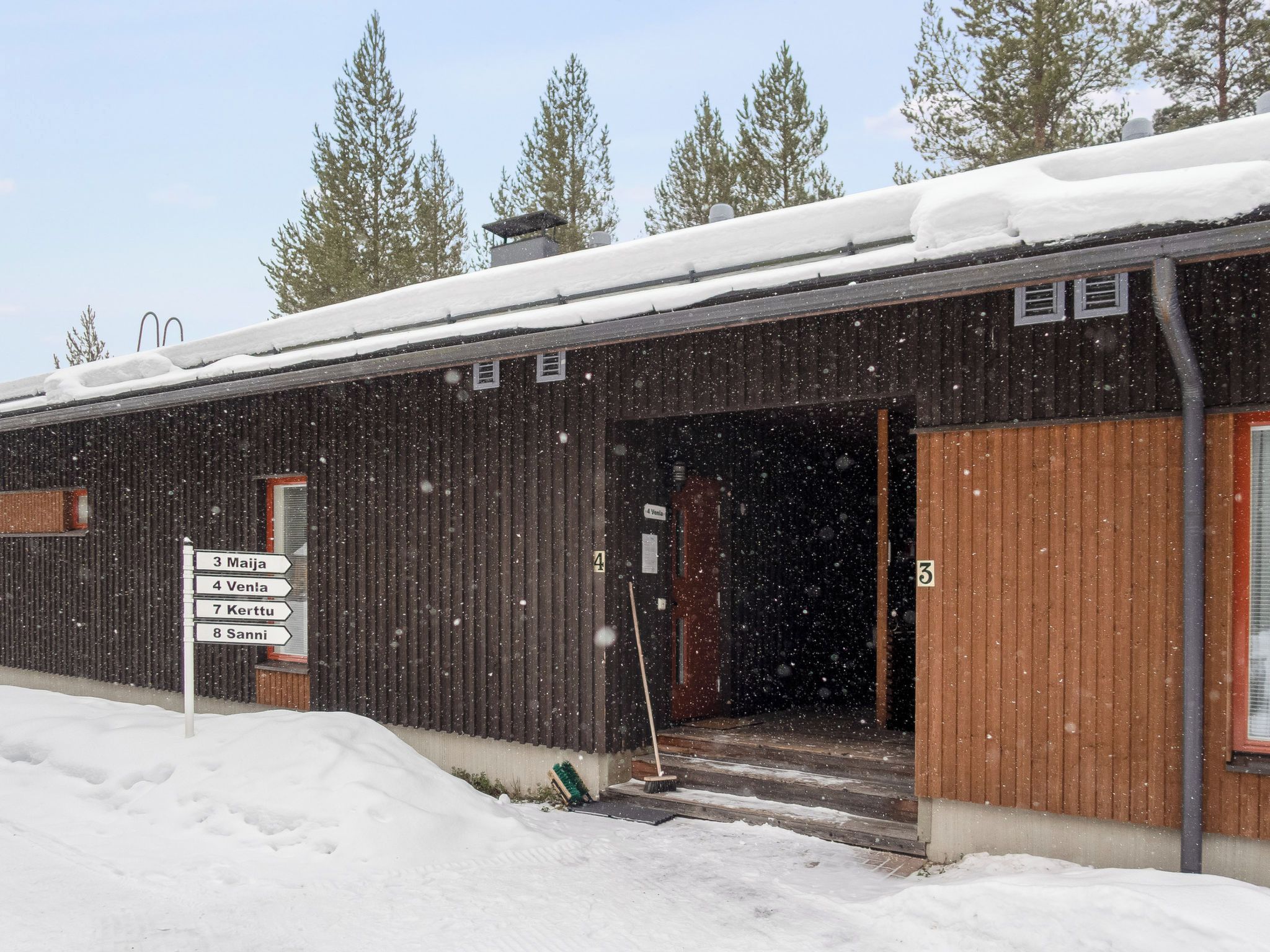 A wooden building with a sign indicating directions to nearby locations.