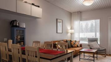Un salon moderne comprenant un coin repas, un canapé, une table basse et un fauteuil.