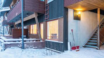 Un immeuble à plusieurs étages doté d’un balcon en bois, de grandes fenêtres et d’un escalier menant à un niveau supérieur.