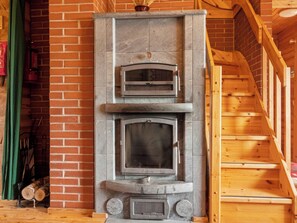Una chimenea de piedra con una escalera de madera.