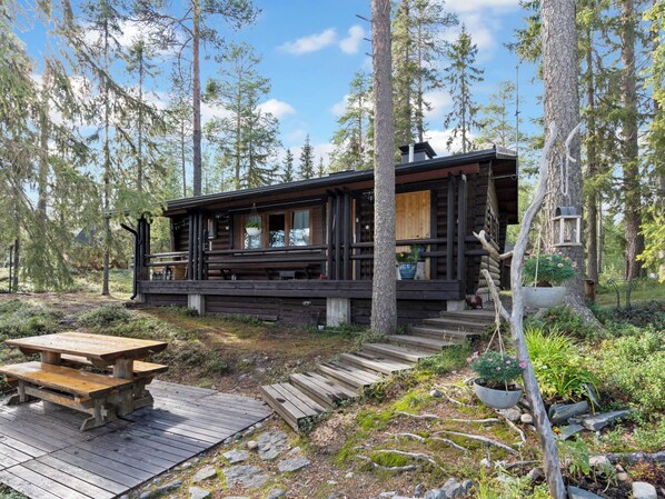 A cabin with a deck, surrounded by trees. - Kesäranta 2 by Interhome (Kuusamo)