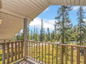 Ein Holzbalkon mit Blick auf einen Wald.