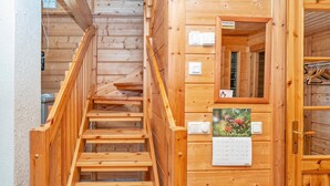 A wooden staircase leading to a room with a calendar and a door with a handle.
