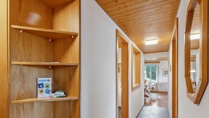 Ein Flur mit Holzböden, einem Spiegel und Blick in einen Essbereich.