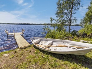 A wooden dock extending into a calm lake, with a small rowboat tied to it. - Ruka-kitkan käki by Interhome (Kuusamo)