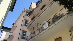 A multi-story residential building with balconies, windows, and a clear sky.