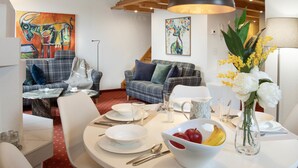 A dining area with a round table set for four, surrounded by two sofas and a floor lamp. - Chalet Abendrot apARTments by Interhome (Grindelwald)