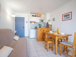 Um espaço compacto com cozinha compacta, área de refeições e sofá.