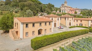 A villa with multiple buildings, a central courtyard, and a hilltop view.