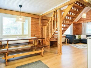 Un interno in legno con una scala, un tavolo da pranzo e un divano.