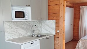 Une cuisine compacte équipée d’un four à micro-ondes encastré, d’un évier et d’un lave-vaisselle.