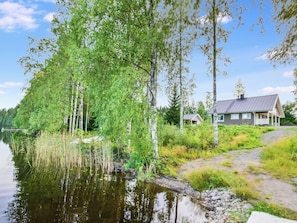 A lakeside property with a house, a dock, and a pathway leading to the house.