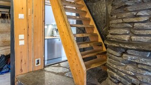 Una escalera de madera con una pared de piedra a un lado.