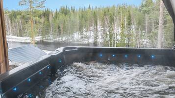 Un jacuzzi con vistas a un área boscosa y un río.