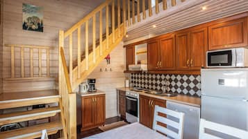 A kitchen with wooden cabinets, a microwave, a stove, and a refrigerator.