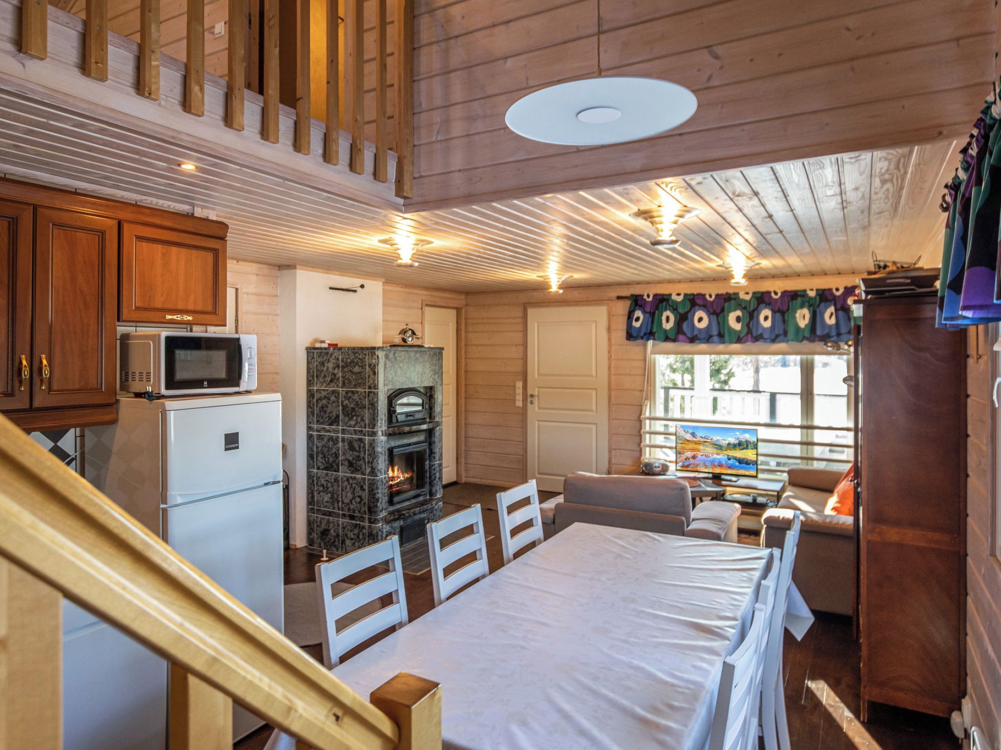 Un interior de cabaña acogedor con cocina, comedor y chimenea.