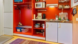 Eine kleine Küche mit Mikrowelle, Kaffeemaschine und einem kleinen Kühlschrank.
