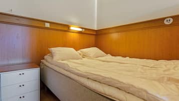A bedroom with a single bed, a nightstand, and a dresser.