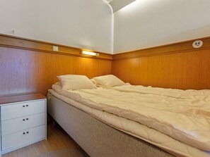 Une chambre avec un lit simple, une table de chevet et une commode.