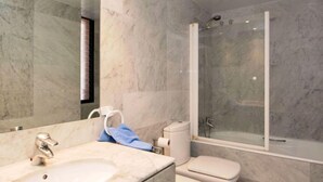 A bathroom with a marble sink, a toilet, and a glass-enclosed shower. - Vila Olímpica: Sant Martí - Sardenya by Interhome (Barcelona)