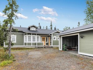 A two-story house with a covered garage and a gravel driveway.