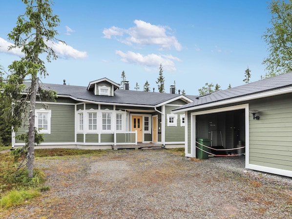 A two-story house with a covered garage and a gravel driveway.